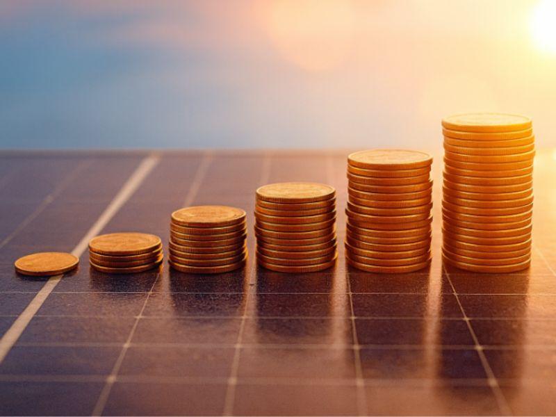 Moedas ilustrativas sobre um painel solar